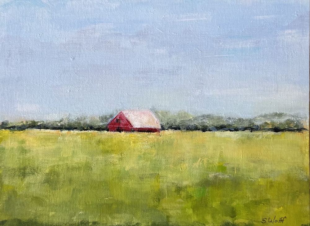 A red barn in a yellow-green field
